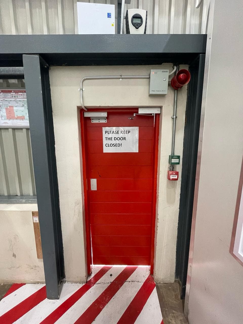 Installed fire door with detection and alarm equipment